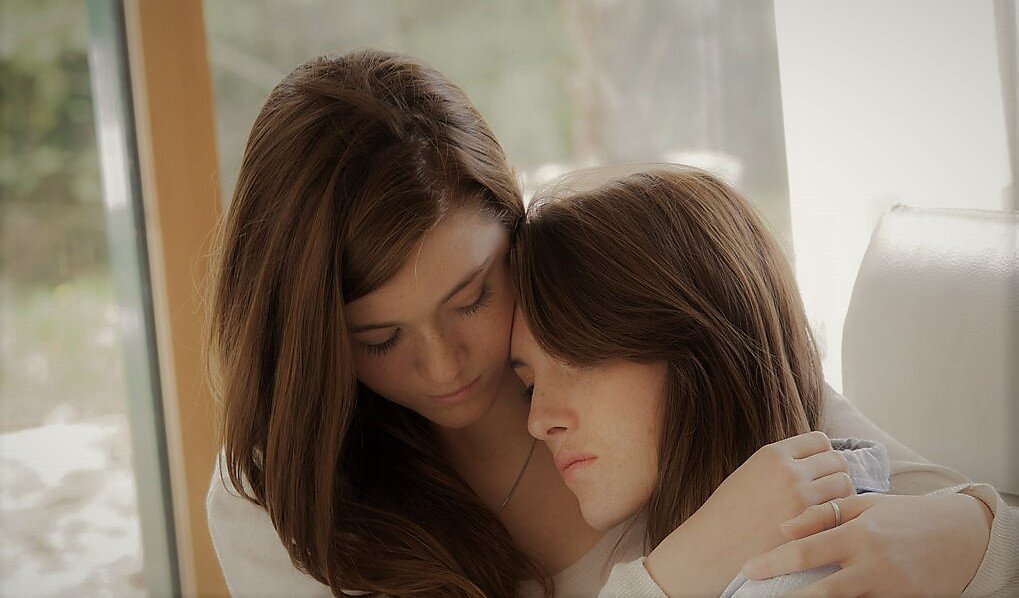 Две сестренки спят. Нежный поцелуй девушек. Материнская эмпатия. Нежный поцелуй девушек. Фотосессия с подругой дома.