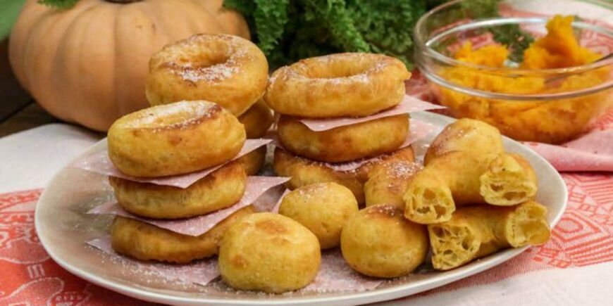 Пончики из тыквы на дрожжах получаются по-настоящему воздушными, пористыми на срезе и с красивой золотистой корочкой. Благодаря добавке в муку молотой корицы, мускатного ореха, кардамона и ванильной эссенции, выпечка вкусно пахнет пряностями. Тыквы в рецепте пончиков совсем не много, поэтому на вкус она почти не чувствуется, но зато заметно окрашивает тесто в аппетитный желтоватый цвет
