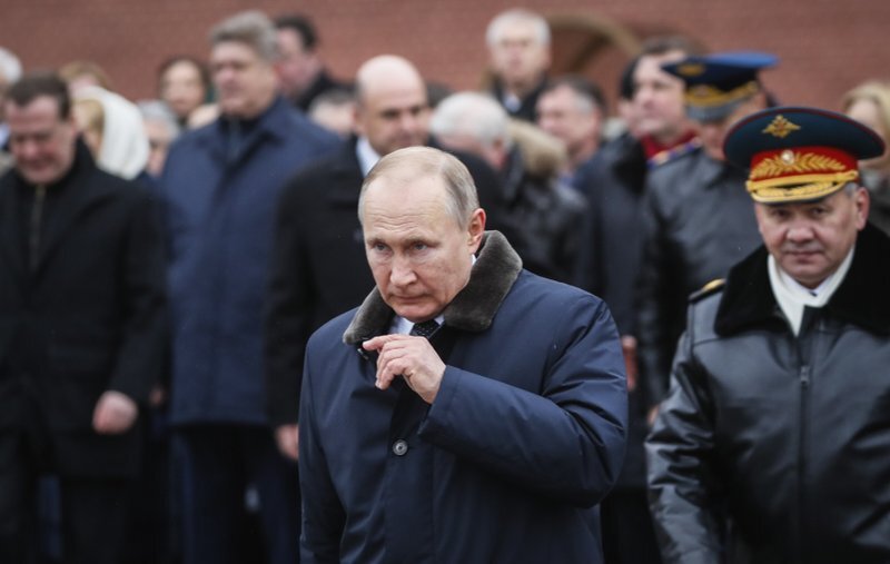 Президент России Владимир Путин, центр, принимает участие в церемонии возложения венков к Могиле Неизвестного Солдата, расположенной недалеко от Кремля, во время празднования Дня Защитника Отечества в Москве.