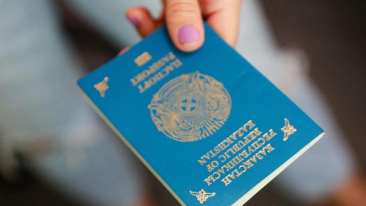    Женщина держит казахстанский паспорт в руках:NUR.KZ/Петр Карандашов