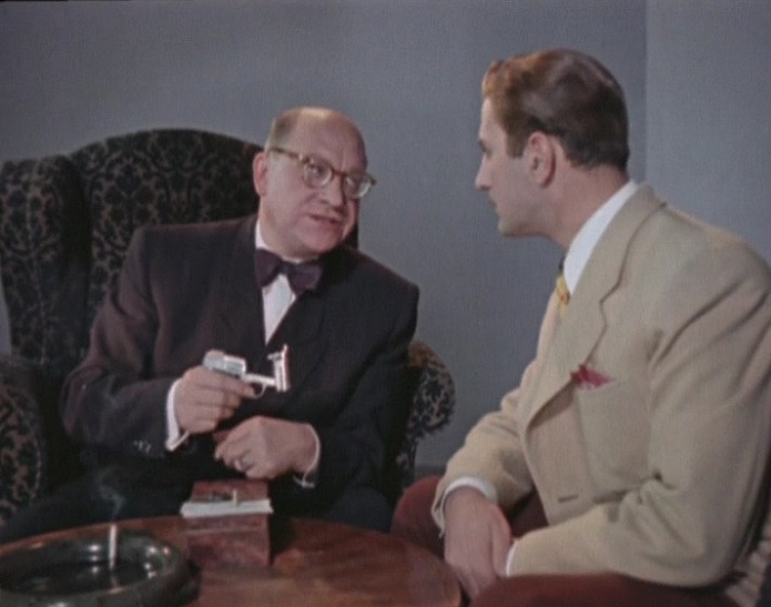 Шеф западной разведки вставляет в пистолет капсулу-патрон с фильмом