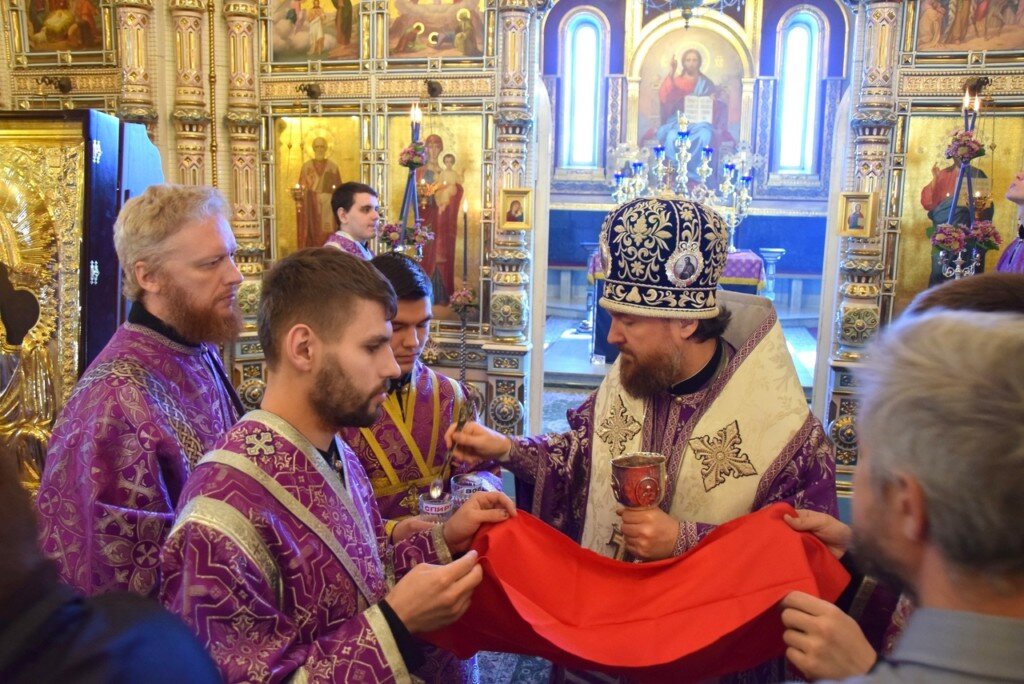 на фото архиерей дезинфицирует лжицу. взято с сайта "sim-sobor.cerkov.ru"