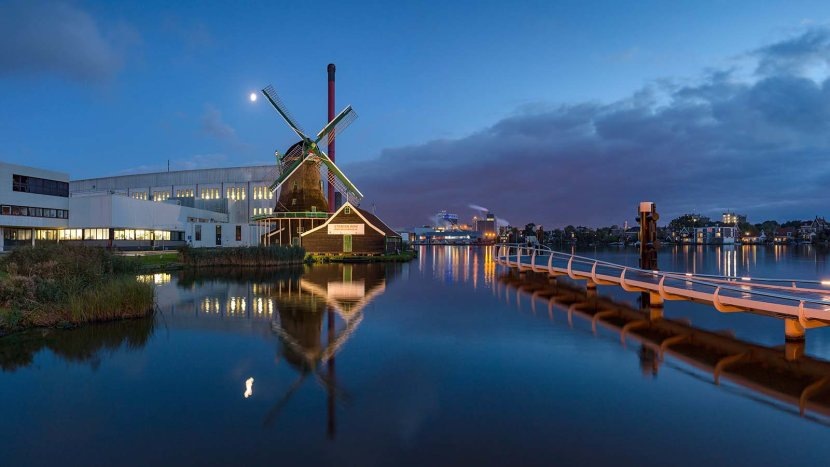 Ветряная мельница под названием "Аист" все еще функционирует на заводе по переработке какао и шоколада Duyvis на реке Заан, Нидерланды.