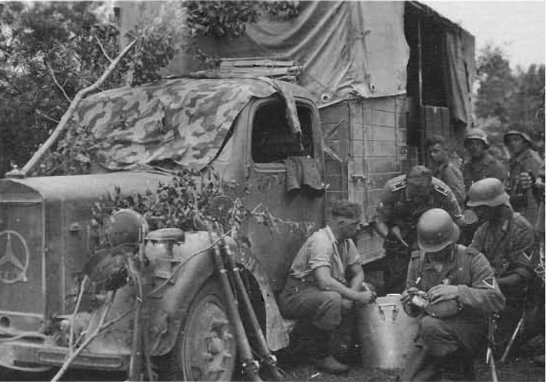 Конец июня 1941 года. Бойцы 402-го мотоциклетного батальона из состава 13-й армии под командованием генерал-полковника Георга фон Кюхлера принимают еду с армейской трехтонки Mercedes-Benz Type L 3000 S перед штурмом Риги. Маскировка грузовика скорее для проформы - в небе господствует Люфтваффе, а партизаны в этой местности в ближайшее время не предвидятся.