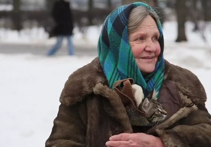 Идет старушка по улице. Бабушка зима. Пожилая женщина в платке. Зимой у бабушки в деревне. Деревенская бабушка.