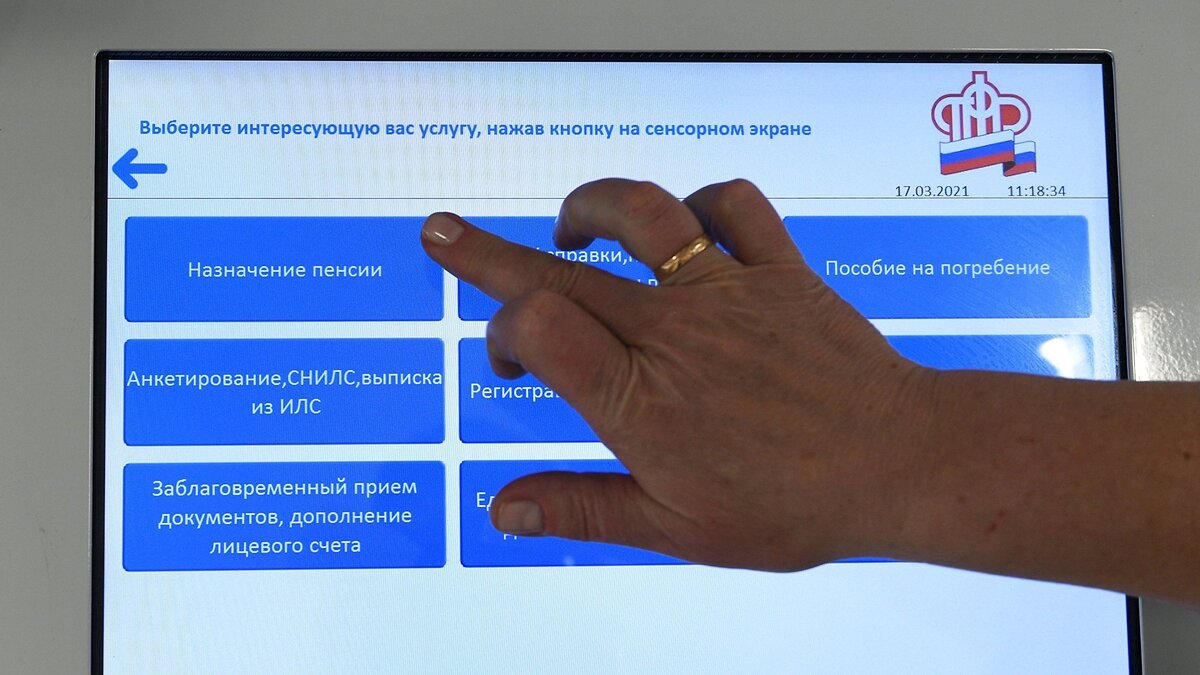    Человек выбирает услугу в терминале в ПФР в Москве.© РИА Новости . Максим Блинов