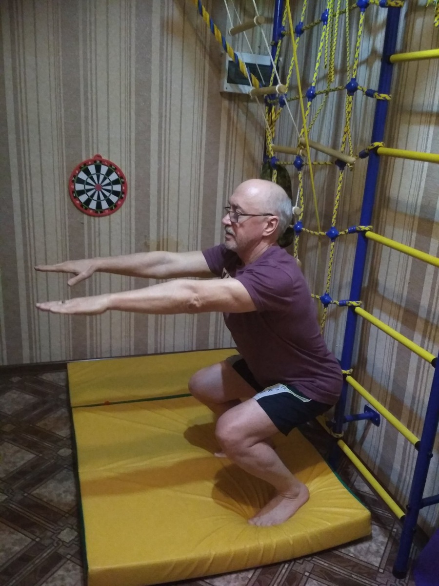 Можно развернуться к стенке и приседать, держась за перекладину.