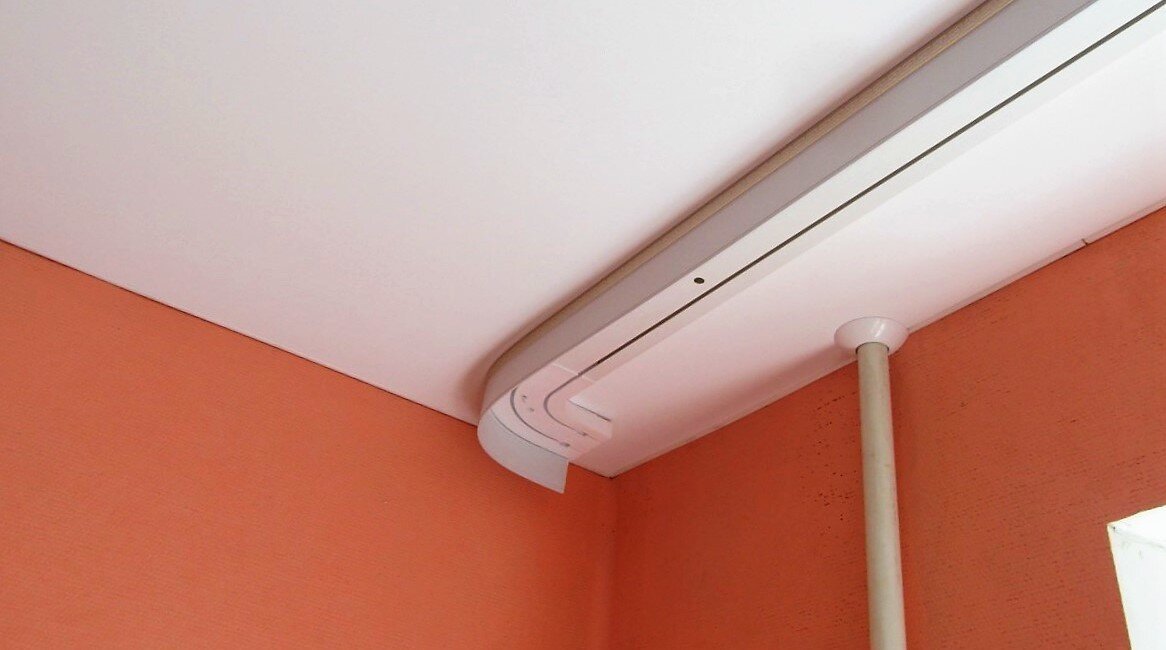 На фото: Пластиковый карниз на натяжном потолке