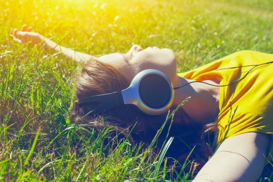 Лето песни июль. Наушники на траве. Девушка в наушниках на траве. Красивая девушка лежит в наушниках. Девушка с фотоаппаратом в траве.