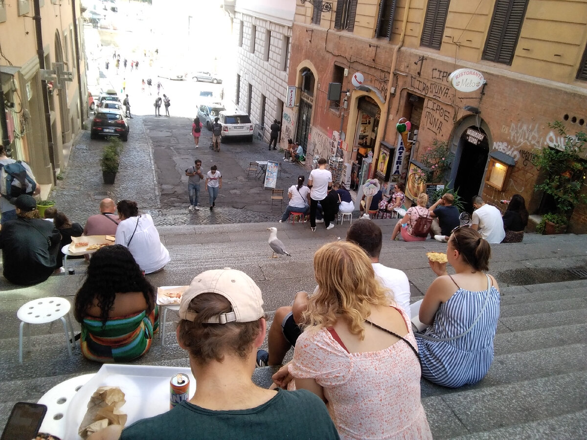 Девушка ест пиццу, чайка расхаживает и посматривает по сторонам, но ее никто не угощает. Рим, фото автора 