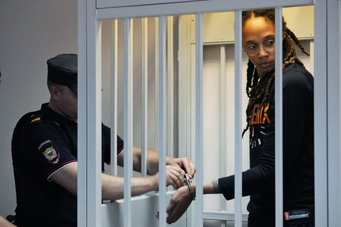 Полицейский снимает наручники с игрока WNBA и двукратной золотой медалистки Олимпийских игр Бриттни Гринер в зале суда перед началом слушаний в Химках под Москвой 27 июля 2022 года. (Alexander Zemlianichenko /AP Photo)