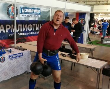 Чуть позже к Андрею Маркину присоединился его товарищ и соперник по мас-рестлингу Александр Гуляев. Он вообще приходил на наш стенд все дни соревнований в перерывах между схватками и каждый раз поднимал гирю, то правой, то левой рукой для разминки. Сейчас он спрашивает будут ли гири бОльшего веса. В принципе глядя на мас-рестлиров, которые даже на пьедестал почета не помешаются такой вопрос кажется вполне закономерным.