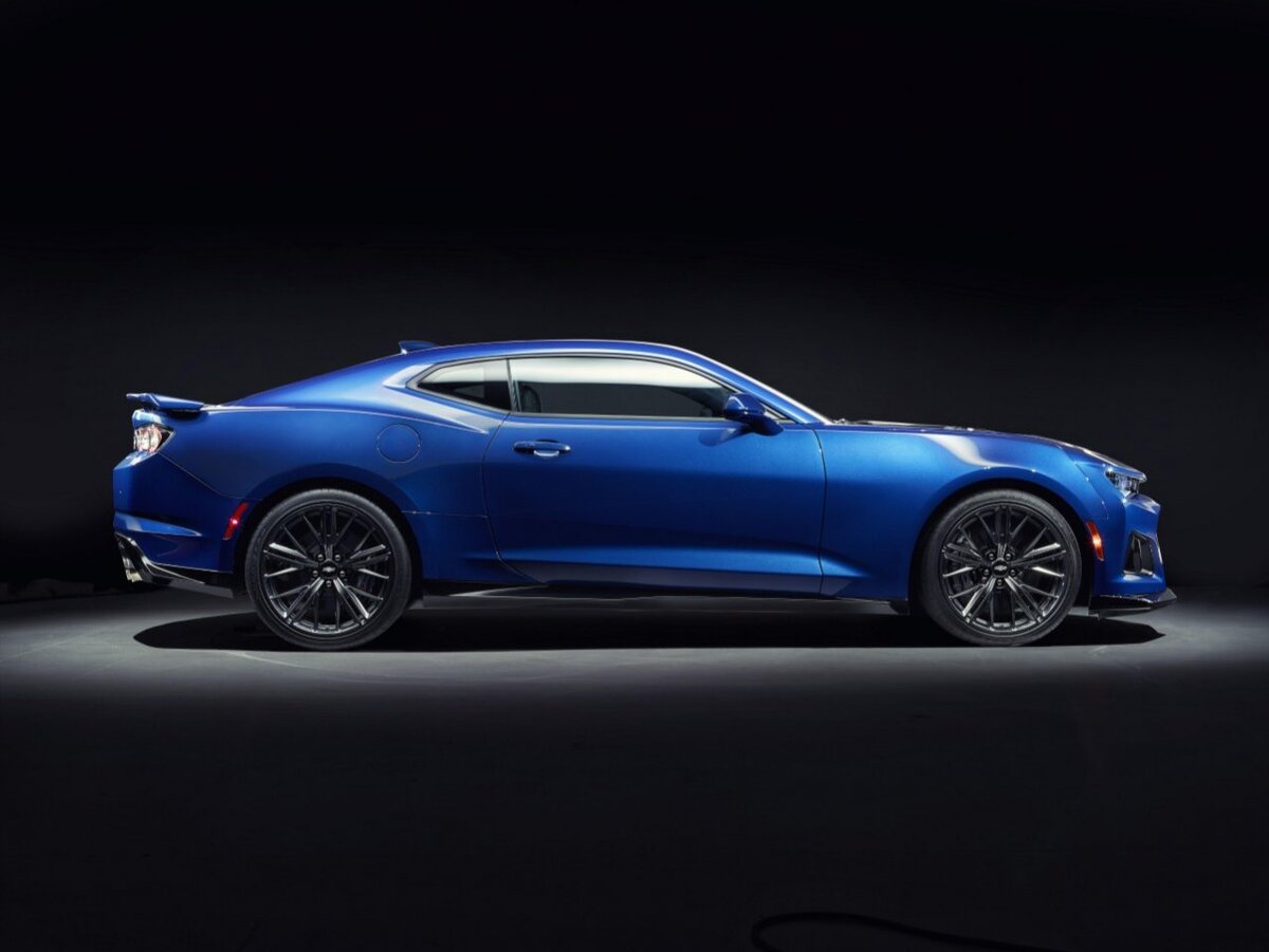 Выглядит Chevrolet Camaro ZL1 куда агрессивнее своего стандартного «собрата», а заслуга в этом принадлежит, упомянутому уже, мощному аэродинамическому обвесу по периметру кузова, рельефному капоту, расширенным колесным аркам, мощному спойлеру и 20-дюймовым дискам оригинального дизайна («завернутым» в покрышки размерностью 285/30/R20 спереди и 305/30/R20 сзади).
