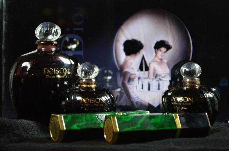 Рекламный постер Пуазона. Девушка в соблазнительном образе на фоне луны, если смотреть издалека, то вырисовывается очертание черепа