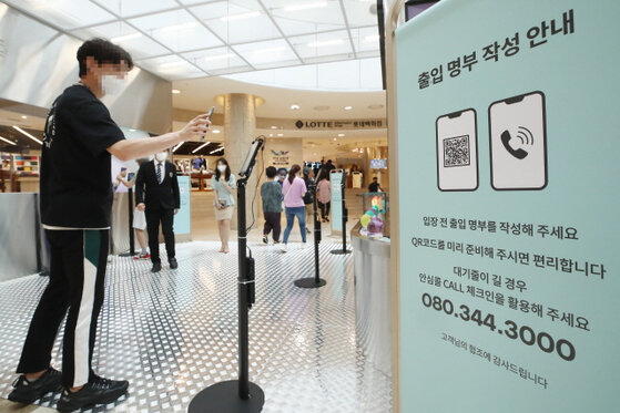 Посетитель универмага Lotte в центре Сеула регистрируется с помощью QR-кода (Ренхап)