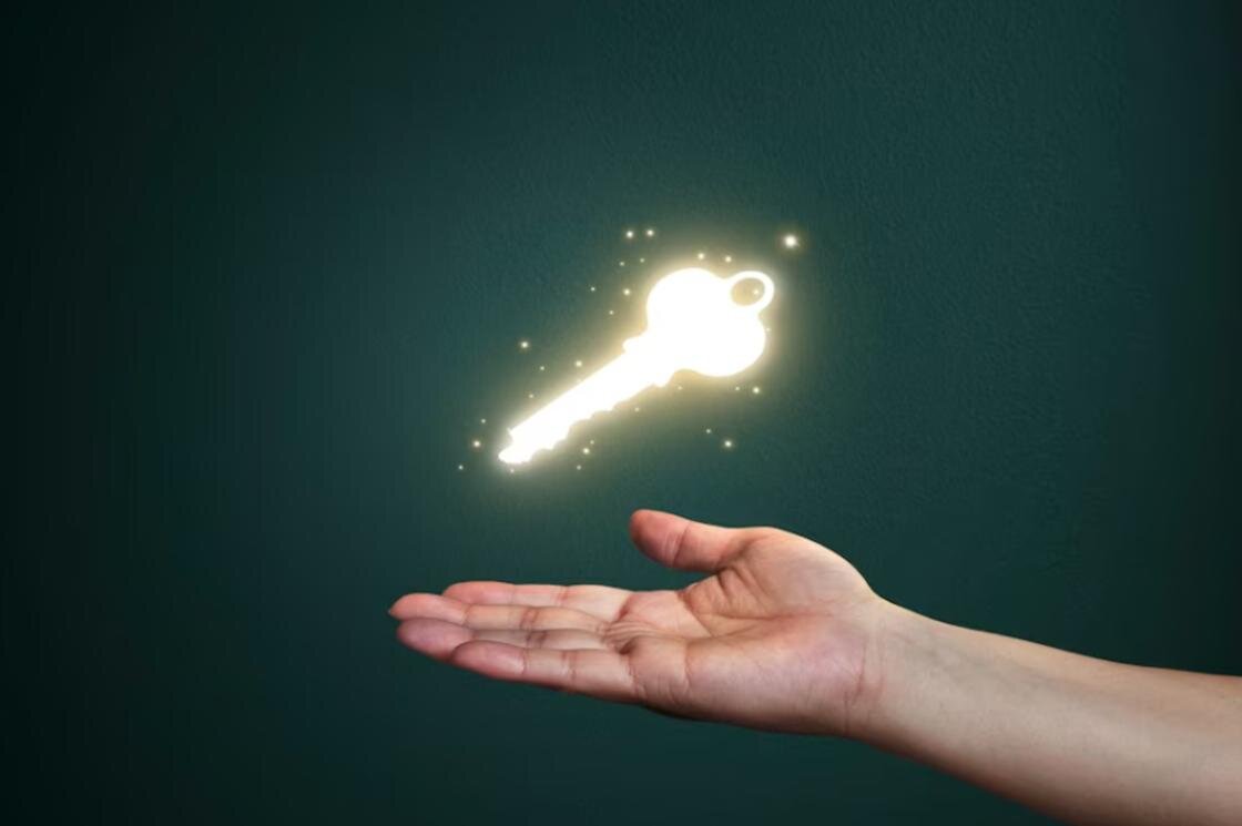    Светящийся ключ висит в воздухе над ладонью:Freepik