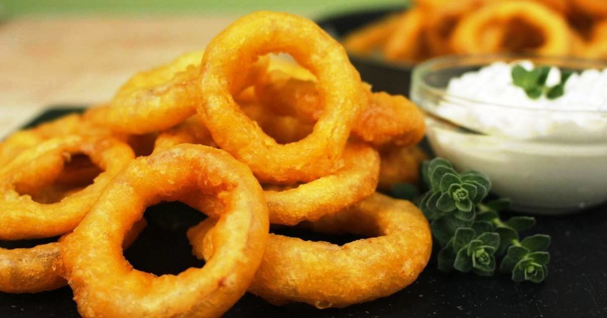 Луковые кольца в кляре. Необычная закуска,.                                                                                                                   3 крупные луковицы;                                                                                                                                                                      2 яйца;
100 г сметаны;
100 г муки;
соль и перец — по вкусу;
растительное масло для фритюра.
Приготовление
Лук очистите, порежьте кольцами и разделите их. Чтобы избавиться от лишней горечи лука, обдайте его кипятком. Удобнее всего это делать в дуршлаге, чтобы сразу же поместить колечки под холодную воду и не дать им свариться.

Приготовьте кляр. Взбейте в пену яйца, добавьте сметану, муку и соль и заболтайте всё венчиком. Если любите острое, можете добавить в кляр перец или горчицу. Кроме того, иногда добавляют тёртый сыр: так кольца получаются более хрустящими.

Посыпьте луковые кольца мукой, а затем обмакните в кляр и опустите в хорошо разогретое растительное масло. Когда появится золотистая корочка, можно вынимать. Готовые луковые кольца выложите на бумажные полотенца, чтобы убрать лишний жир.

Подавать можно с любым томатным соусом.   