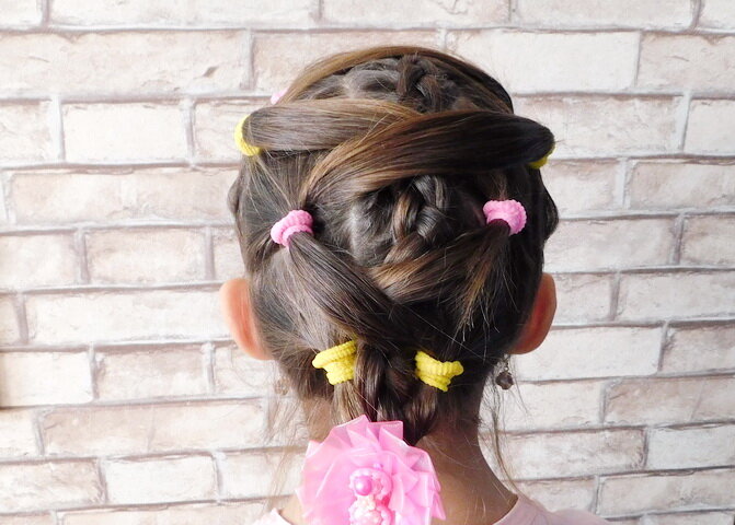 Очень легкая прическа. Изначально посередине заплетите косичку, а затем по бокам делайте хвостики и соединяйте их между собой, как показано на фото.