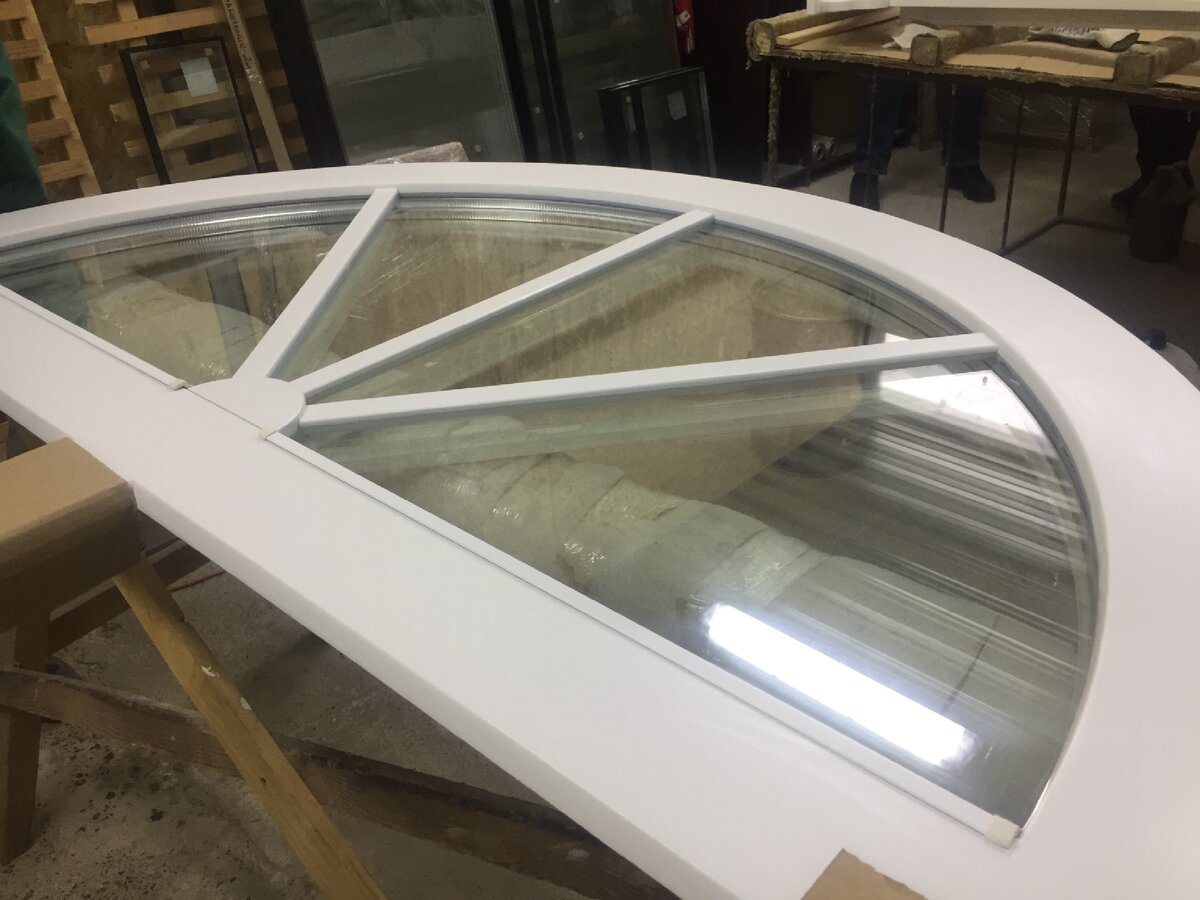 Глухое деревянное окно с декоративными накладками в виде "солнечных лучей".