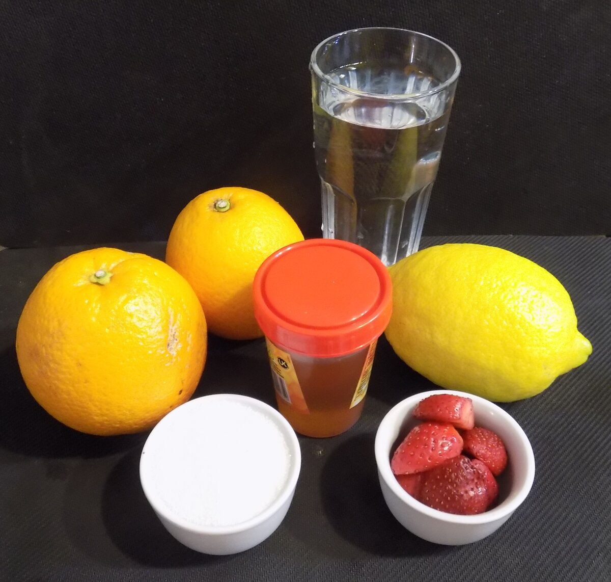 Все необходимые ингридиенты для напитков, представленных в статье. апельсины, лимоны, мед, сахар клубника и вода.