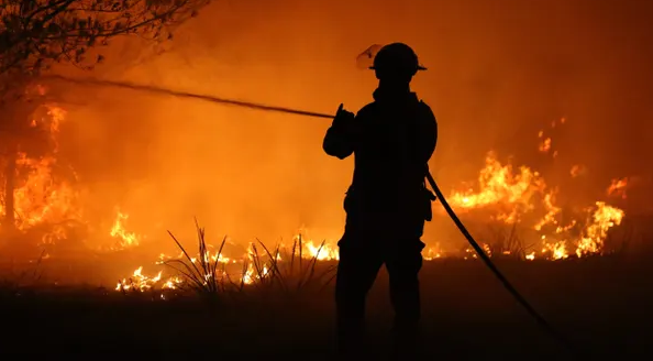 Пожарный борется с лесным пожаром на южном побережье штата Новый Южный Уэльс в четверг. Дым от пожаров будет способствовать глобальному росту концентрации углекислого газа в атмосфере.