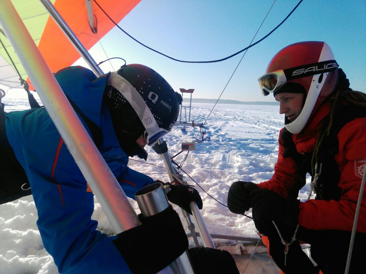 Инструктор готовит ученика к полёту на дельтаплане