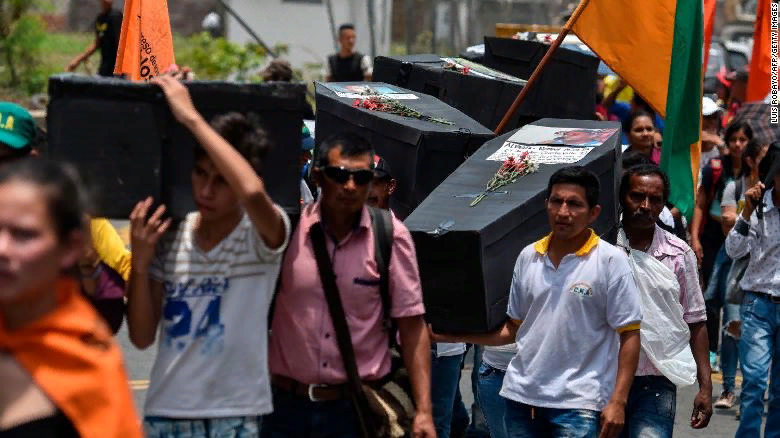 Жители несут импровизированные гробы в знак солидарности с жертвами насилия в Кали, Колумбия, в апреле 2018 года.