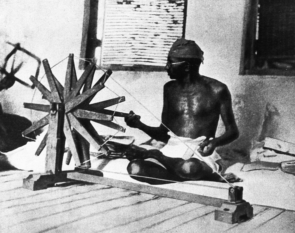 Махатма Ганди крутит хлопкоуборочную машину. Индия, 1910 г. Getty Images