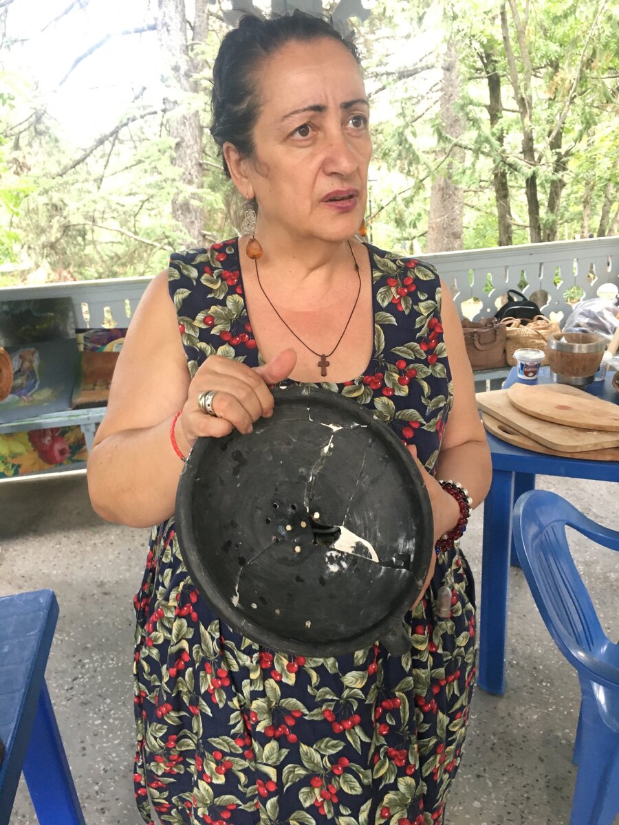 Анна держит в руках музейный экспонат, кувшин, в котором делали сыр тысячелетия тому назад.