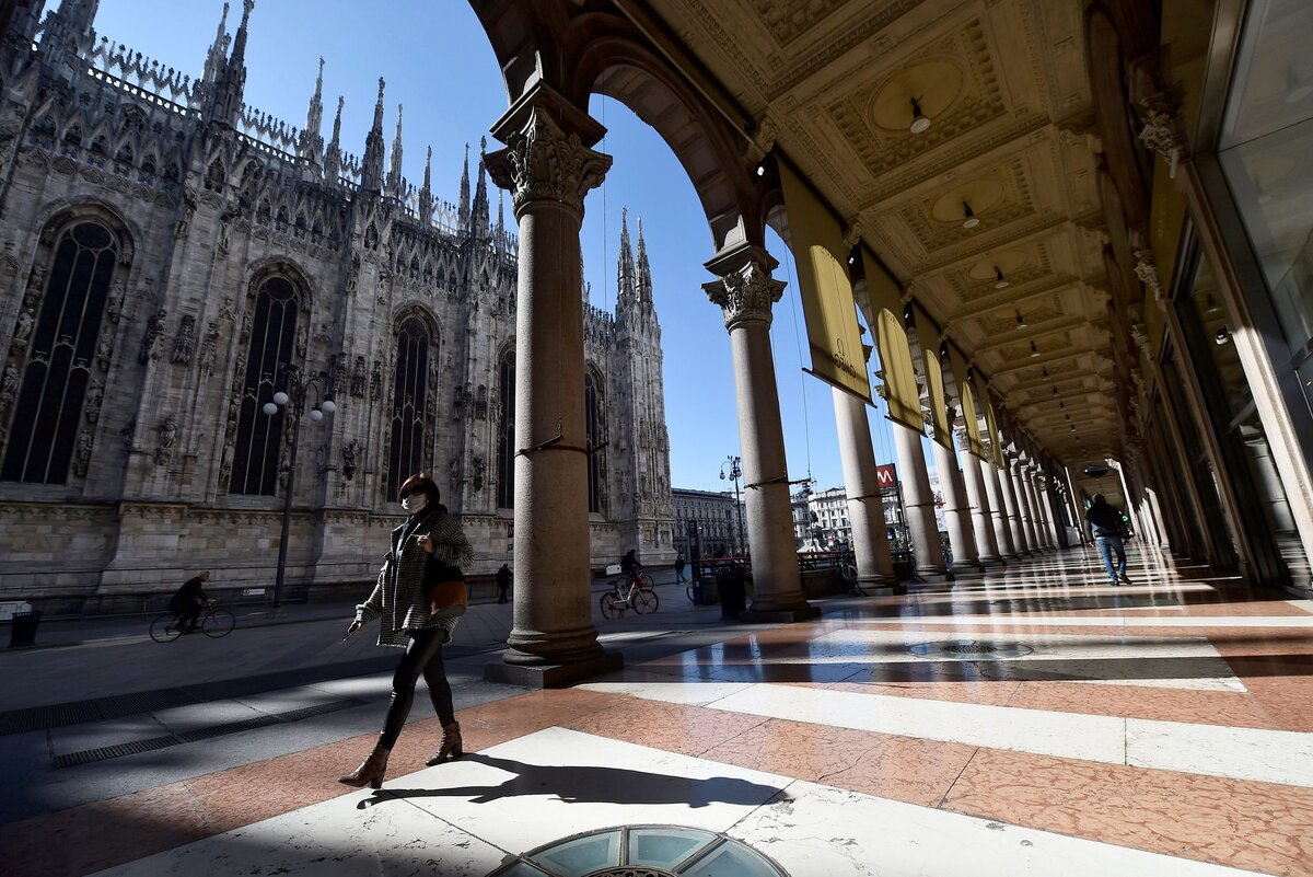 Пустые улицы главной площади Милана - Duomo и женщина в маске (Фото: REUTERS)