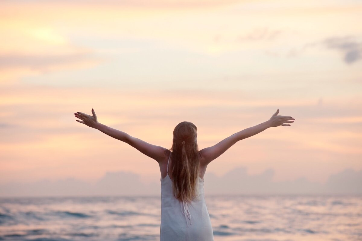 https://www.pexels.com/photo/rear-view-of-woman-with-arms-raised-at-beach-during-sunset-320007/