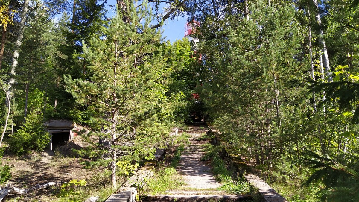 С тропинки маяк уже отчётливо видно. В подвале слева нет ничего интересного, только мусор.