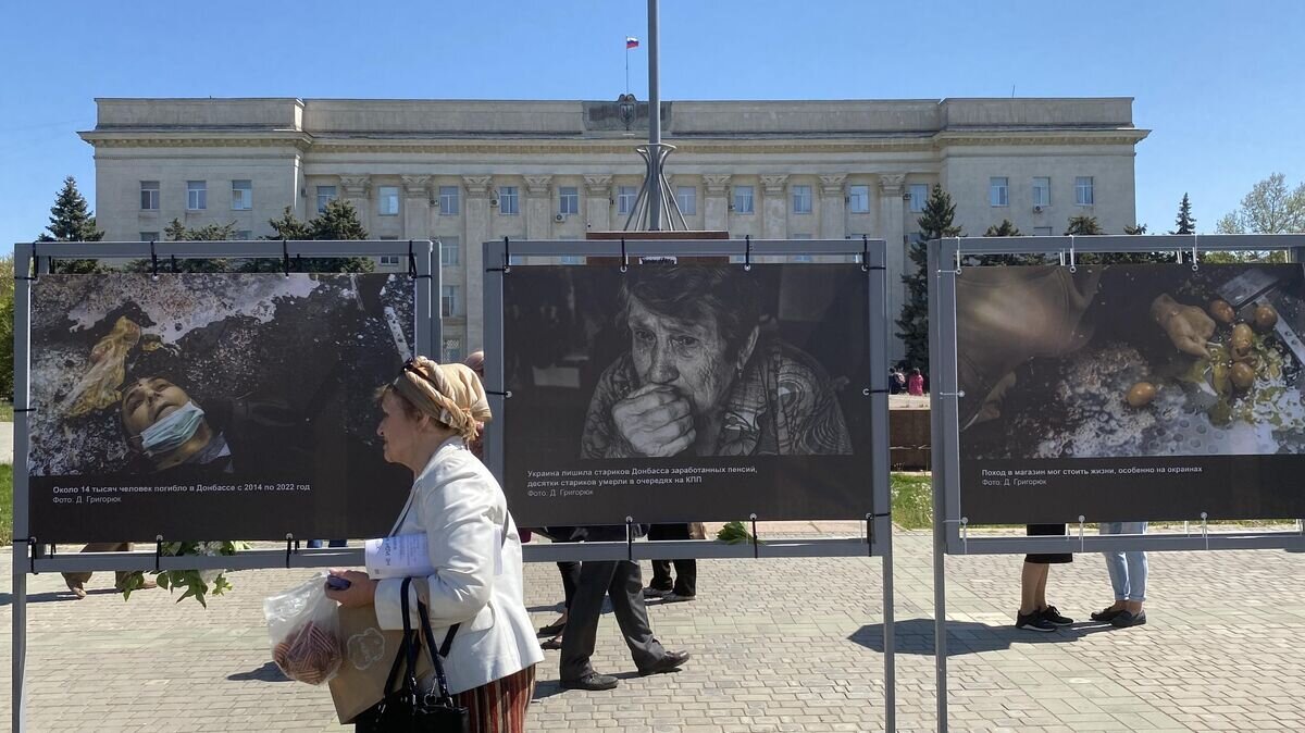    Женщина на площади Свободы в Херсоне, где открылась фотовыставка о преступлениях ВСУ в Донбассе© РИА Новости / Михаил Алаеддин