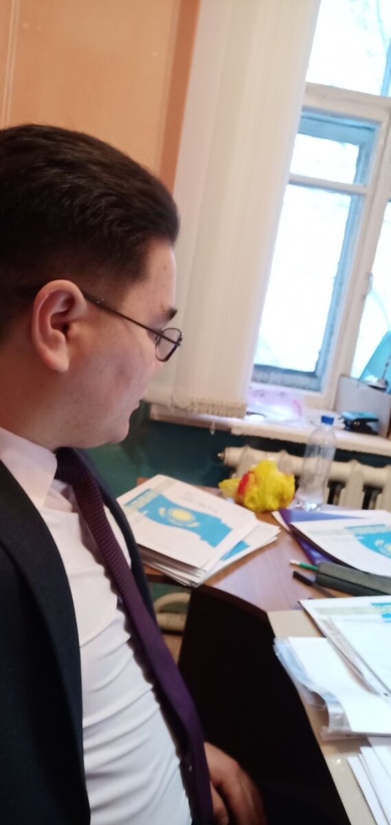 Я на работе в акимате (мэрии). В углу стало видно моя бутылка с водой и яблоко в желтом салафанчике, это мой перекус