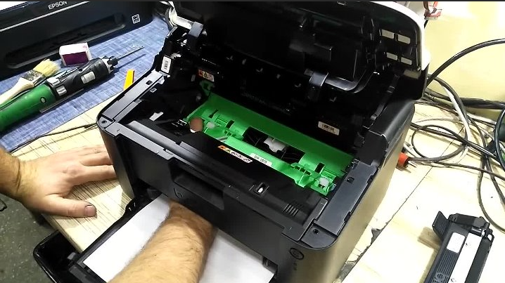 Устанавливаем драм картридж (без без тонер картриджа) назад в принтер и через лоток для выхода бумаги нажимаем на рычаг