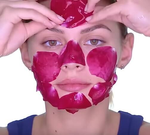 Нанесение маски из лепестков на лицо