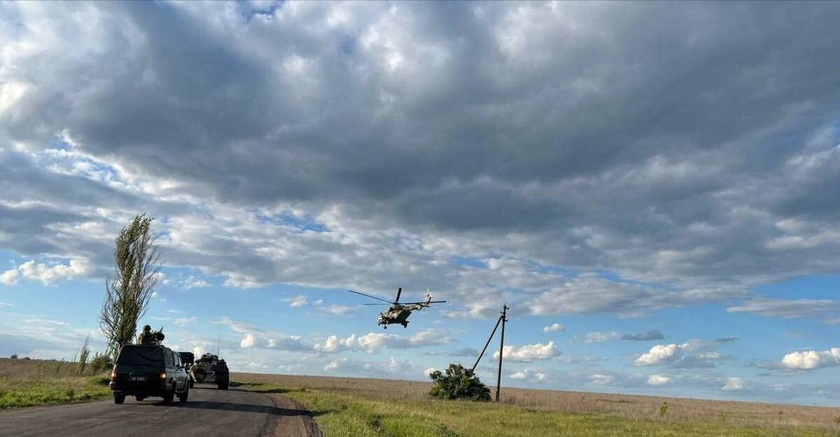 Колонну автобусов с пленными азовцами сопровождает не только военная техника, но и вертолеты - операция организована на высоте.
