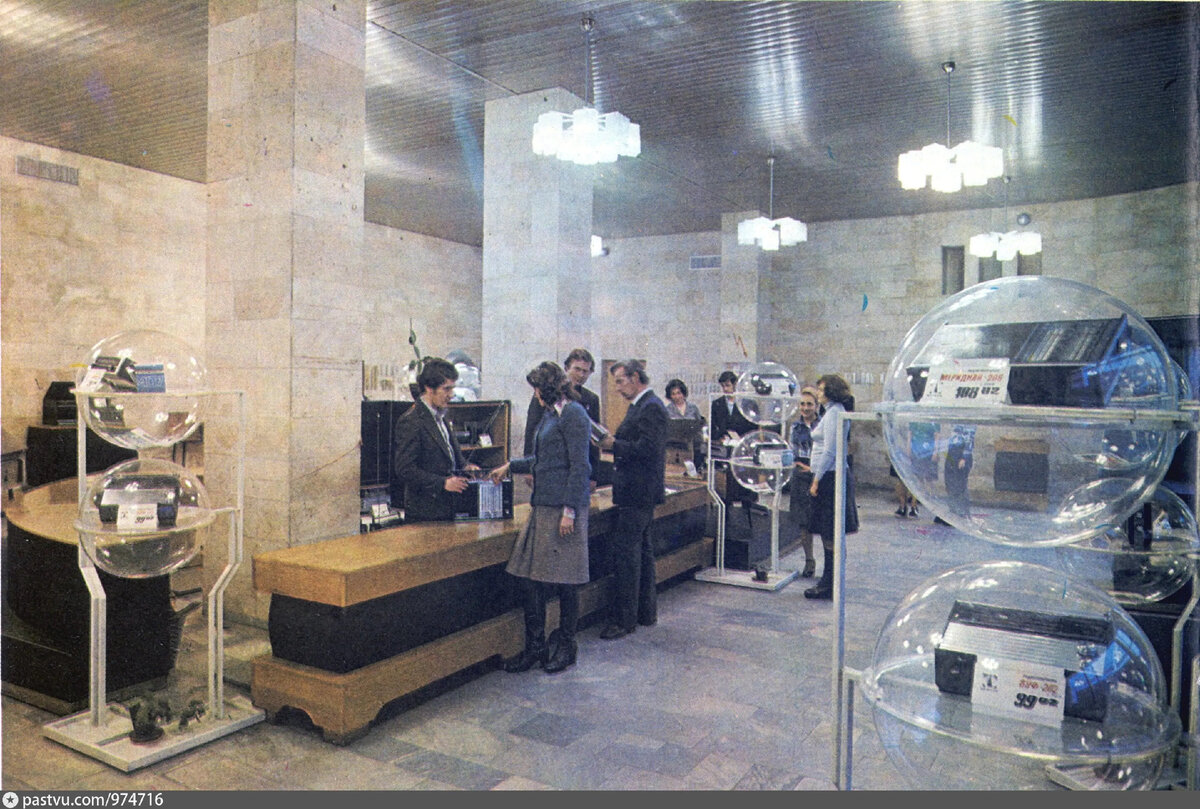 Один из торговых залов магазина "Орбита" в 1977-1978 годах. Здесь хорошо можно рассмотреть сферы. Экспонаты внутри них часто привязывали. Наверное, чтобы не украли. С сайта www.pastvu.com.