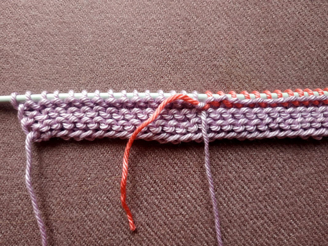 При вводе в вязание нити другого цвета я сразу закрепила ее одним, некрепким узлом к основной, избегая перекосов и отверстий в полотне.