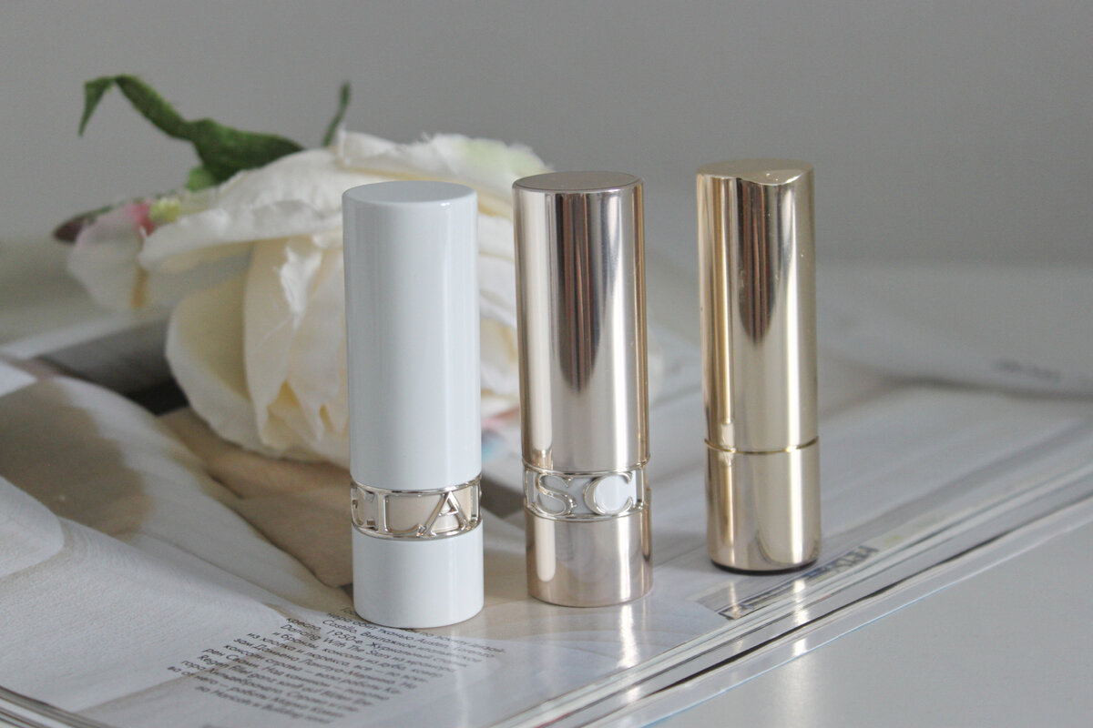 Помады Clarins Jolie Rouge. Слева две новые, после перевыпуска. Справа - старый флакон, до перевыпуска.