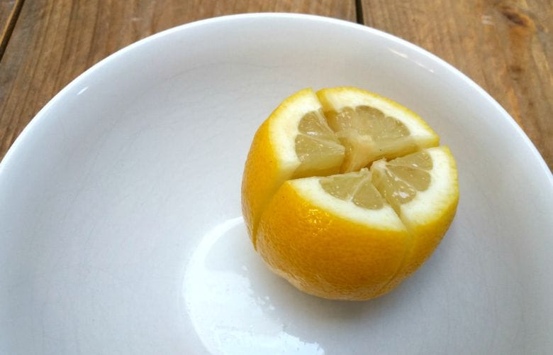 Хурма лимон. Лимон порезанный. Разрезанный лимон. Лимон с солью. Четвертинка лимона.