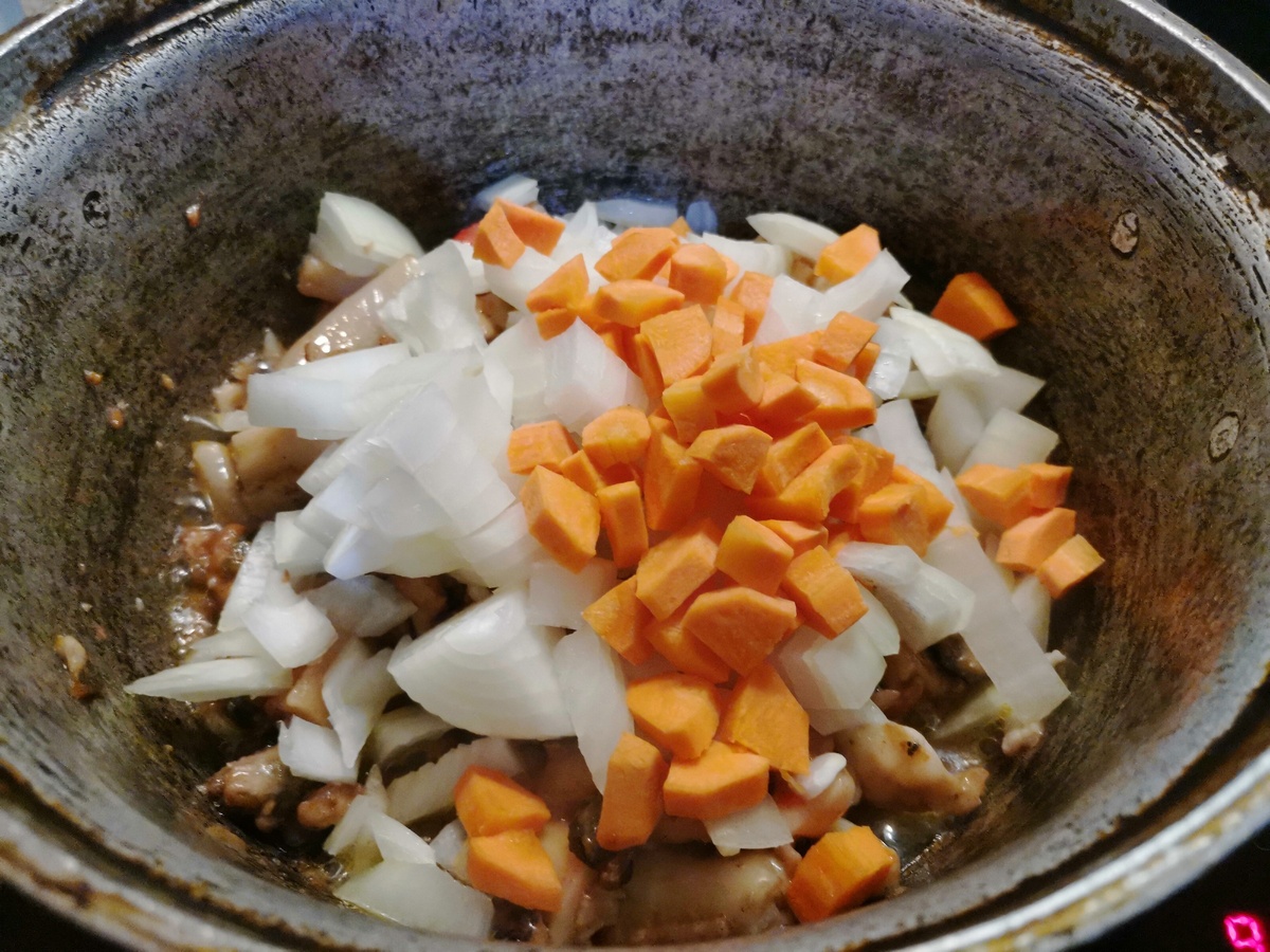 Добавляем нарезанные кубиком лук и морковь. Продолдаем обжаривать.