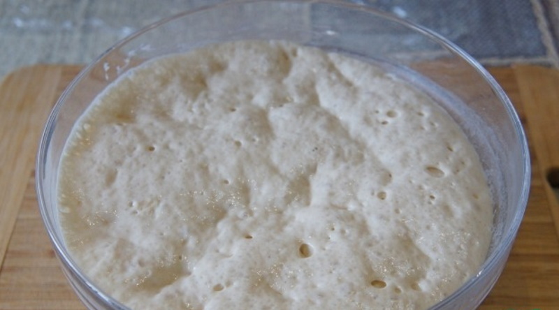 Первым делом приготовь опару. Всыпь в емкость половину муки, добавь дрожжи, влей стакан теплой воды. Помести посуду с опарой в тепло минут на 40, чтобы тесто увеличилось вдвое.