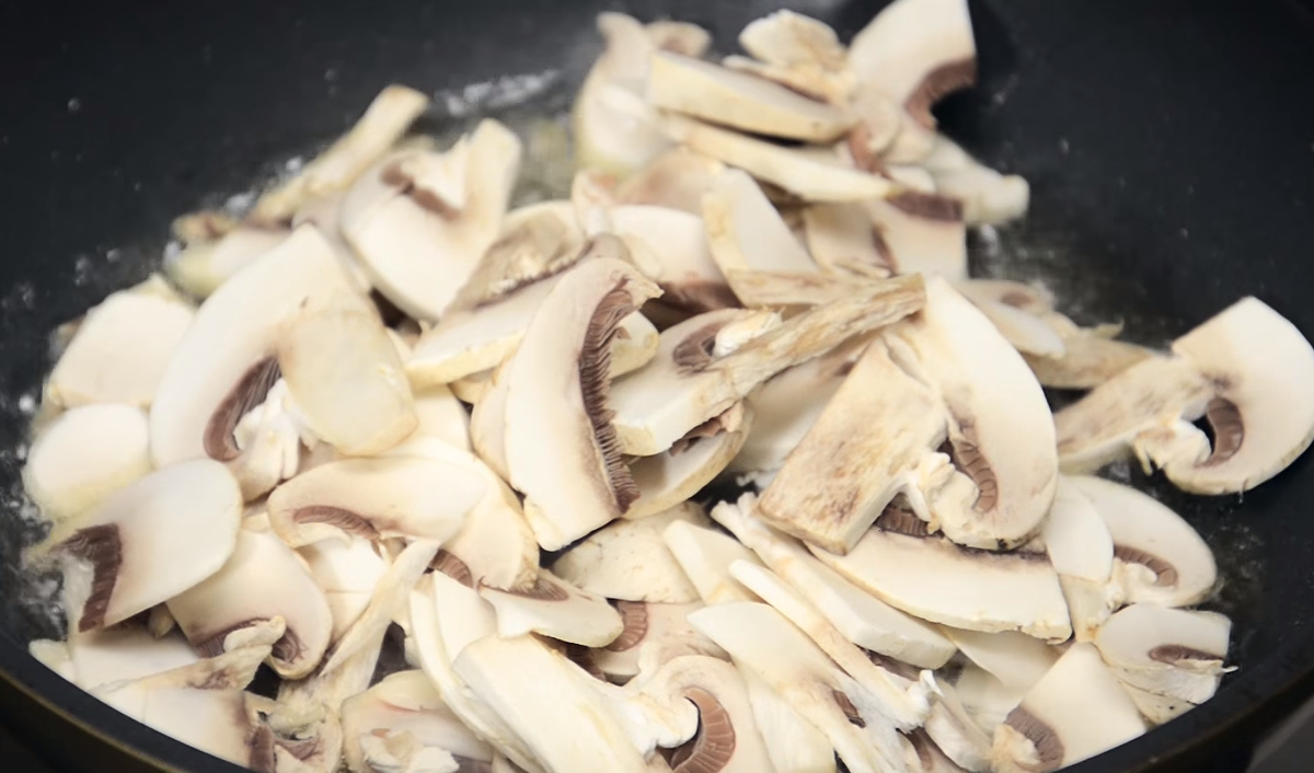 Нарезанные грибы отправить на сковороду и обжарить до полуготовности.