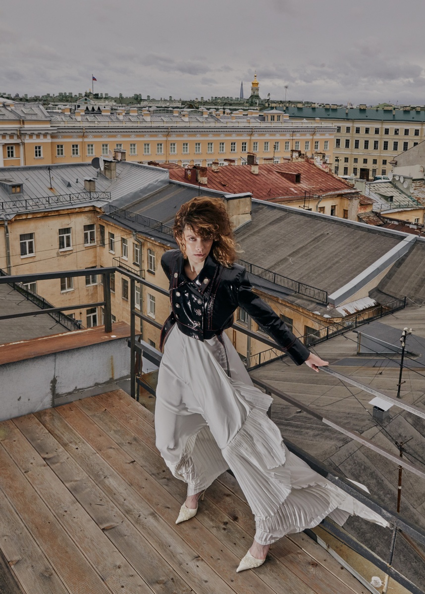 Модель Ольга Кузнецова. Модель в белом платье и чёрной куртке стоит на крыше высокого здания рядом с антенной. В подсознании невольно проскальзывает мысль об эпохе радио и телевидения, популярность которых ещё не так давно была на высоте. 