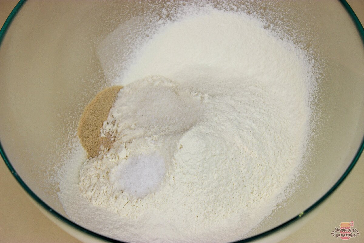 Просеиваем муку (350 гр., затем добавляем частями, чтобы не забить тесто мукой) и добавляем все сухие ингредиенты : дрожжи, сахар, соль, перемешиваем.