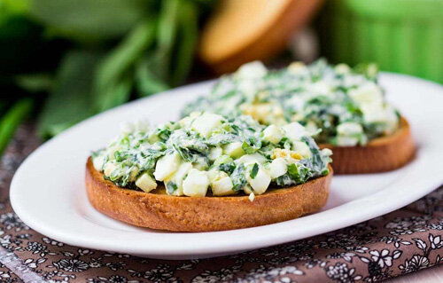 Вам понадобятся:  отварные яйца (2шт.), цельно зерновой хлеб (2 кусочка) или диетические  хлебцы, репчатый лук, укроп, огурец, помидор, диетический майонез (1-2  чайные ложки) или масло (подсолнечное или оливковое 1 чайная ложка),  соль, специи – по желанию.
Приготовление: нарезаем  мелко яйца, лук, огурец, помидор и зелень, добавляем майонез (или  масло), соль и специи, тщательно перемешиваем все ингредиенты и  полученную массу намазываем на хлеб (или хлебцы).