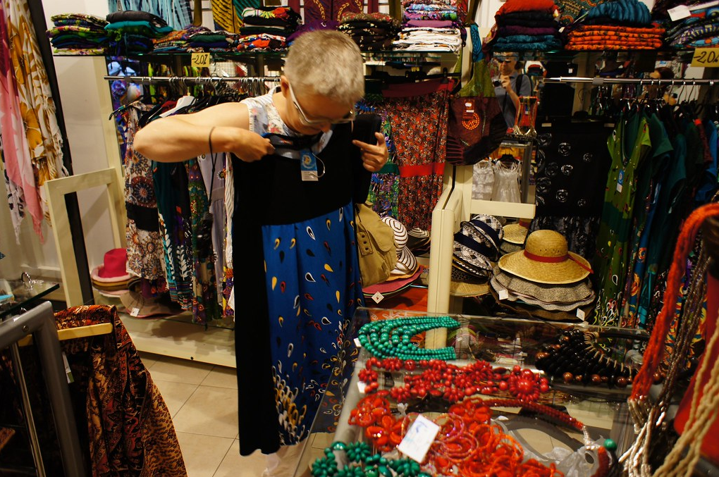 Эта женщина работает, возможно, кассиром… или поваром … или еще кем-нибудь. Она оказывает услуги. И пришла в свой выходной купить красивое платье и здесь ей оказывает услуги продавец, который может вдруг оказаться в том самом магазине – столовой – школе, где работает пришедшая к нему сегодня женщина. 

А та вдруг как вспомнит его. И что она вспомнит? Если продавец помог ей выбрать нужную вещь, то добавит полполовника борща сверх нормы. А если все прошло не очень гладко – плюнет в тарелку. Все же взаимосвязано…
Фото https://www.flickr.com/photos/a2clay/ 