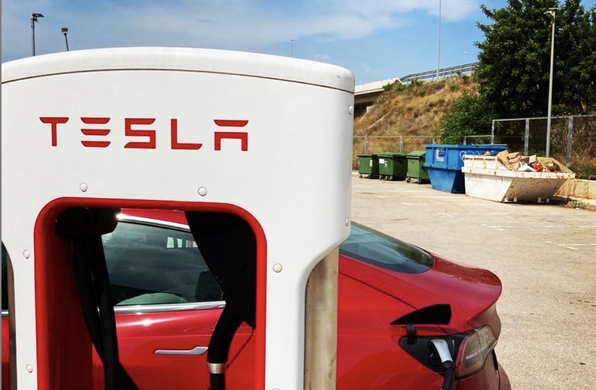 Зарядка Теслы, рядом с мусорными контейнерами