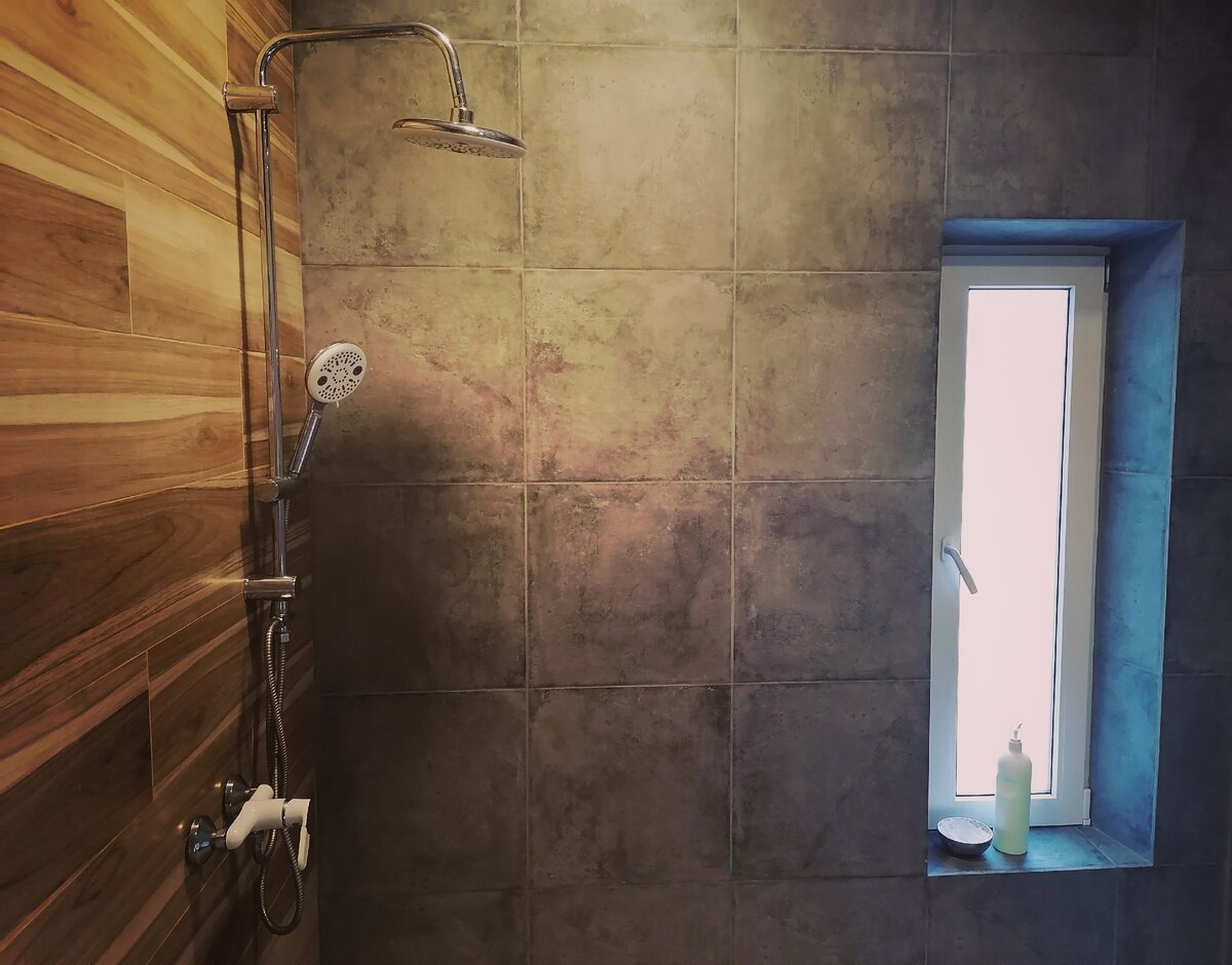 Напольная плитка переходит на одну из стен- это решение не дает бетону преобладать.
Есть узкое тонированное окно и помещение легко проветривается. Имеется вытяжка.